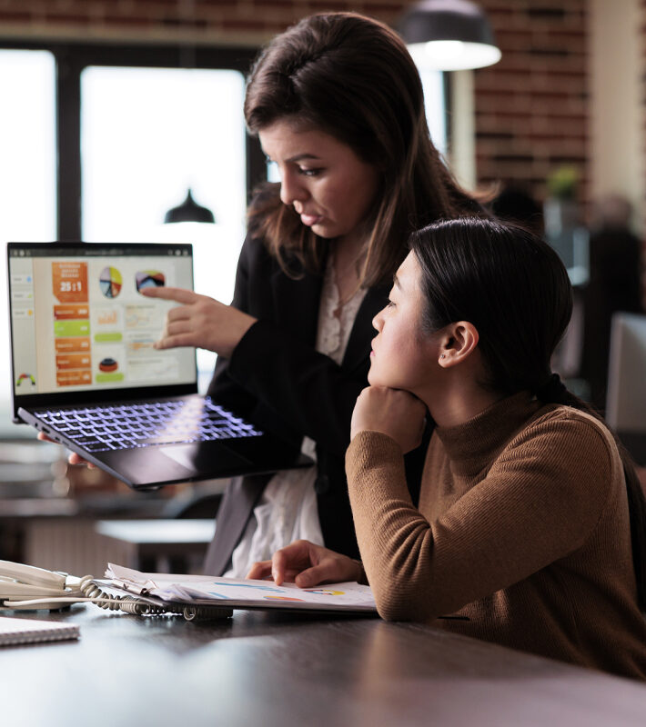 Asian woman living with disability talking to colleague